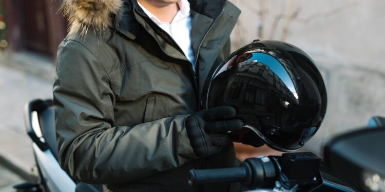 un motard, casque à la main