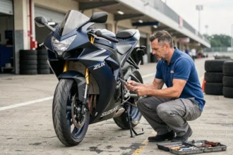 Mécanicien réglant la suspension d'une Suzuki GSXR dans les stands d'un circuit de course pour une préparation piste